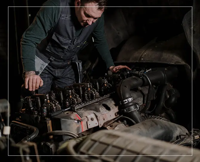 A man working on an engine in a garage.